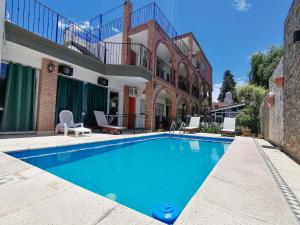 uma piscina em frente a uma casa em Posada El Betel em Villa Carlos Paz