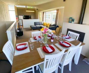 a dining room table with white chairs and a dining room at Tekau - Modern holiday apartment with lakeview in Queenstown