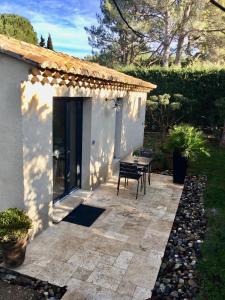 a patio with a table and a bench next to a building at Mazet LEAJO in Eygalières