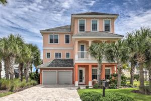 a large house with palm trees in front of it at Palm Coast Oasis with Pool Steps to Cinnamon Beach! in Palm Coast