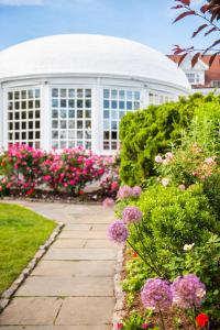 a garden with flowers in front of a white building at The Inn at Longshore in Westport