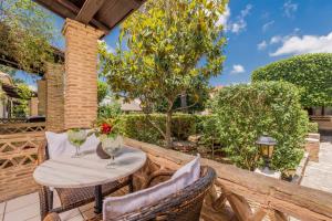 eine Terrasse mit einem Tisch und Stühlen auf einem Zaun in der Unterkunft Garden Village Studios & Apartments in Kalamaki