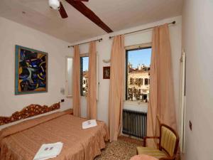 a bedroom with a bed and a window at Hotel Antico Capon in Venice