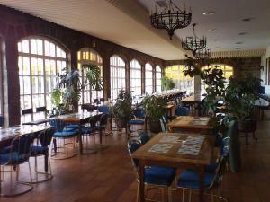 a dining room with tables and chairs and windows at Hotel Temple Pradorrey in Astorga