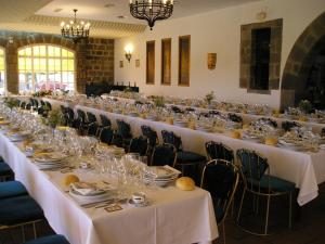 a long table in a room with white tables and chairs at Hotel Temple Pradorrey in Astorga