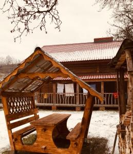 a wooden bench in front of a house at Золото Карпат in Izki