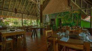 an empty restaurant with wooden tables and chairs at Esquinas Rainforest Lodge in Golfito