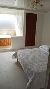 een slaapkamer met een bed en een raam bij Hotel Mi Gloria in Tunja