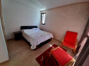 サレにあるAppartement calme sur mer et piscineの小さなベッドルーム(ベッド1台、赤い椅子付) +35枚の写真