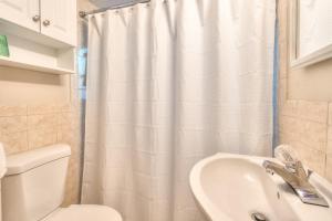 baño con cortina de ducha blanca y lavamanos en Tropic Terrace #18 - Beachfront Rental condo, en St Pete Beach