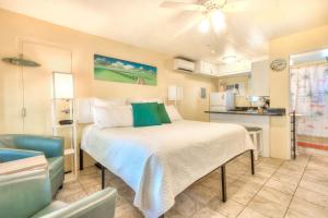 a bedroom with a large bed and a kitchen at Tropic Terrace #22 - Beachfront Rental condo in St. Pete Beach