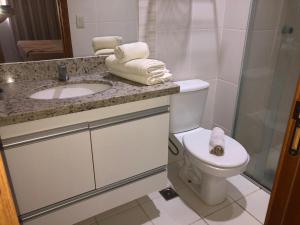 a bathroom with a toilet and a sink and a shower at Veredas Rio quente flat in Rio Quente