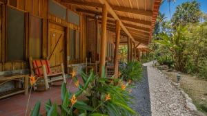 uma casa com um alpendre com uma cadeira e uma mesa em Esquinas Rainforest Lodge em Golfito