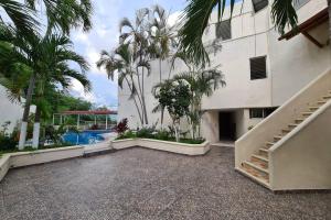 an external view of a building with palm trees and a swimming pool at 64 Peninsula del Capitan in Manzanillo