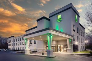 Un gran edificio blanco con luces verdes. en Holiday Inn Cheshire - Southington by IHG, en Southington