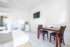 a bedroom with a desk and a bed and a bed and a desk at Motel Ingham in Ingham