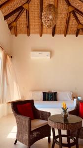 um quarto com uma cama, uma mesa e cadeiras em Hotel Estrella de Mar em Zipolite