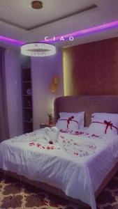 a bedroom with a white bed with red flowers on it at طيف للأجنحة الفندقية in Al Kharj