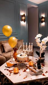 阿爾卡的住宿－طيف للأجنحة الفندقية，一张桌子,上面放着气球,上面放着蛋糕和蜡烛