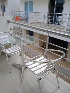 a glass table and two chairs on a balcony at Hotel Portobello in Coveñas