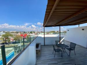 ein Balkon mit Stühlen und einem Tisch an einem Gebäude in der Unterkunft Hotel Maria Sofia ViaCapu in San Felipe Hueyotlipan
