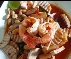 a bowl of shrimp and pasta with peanuts and sauce at TR Guesthouse in Sukhothai
