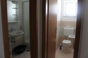 a bathroom with a toilet and a sink at Apartman Leana in Krk +8 photos