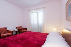 a bedroom with a large bed with a red blanket at Apartman Leana in Krk