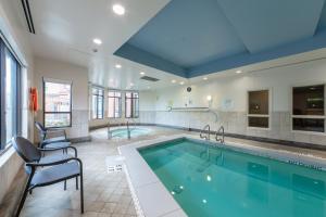una gran piscina con 2 sillas y una piscina en Holiday Inn Express & Suites Riverport Richmond, an IHG Hotel, en Richmond