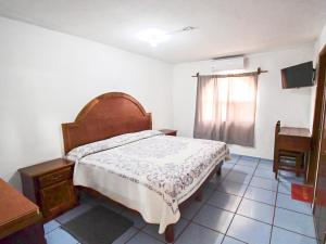 ein Schlafzimmer mit einem Bett, einer Kommode und einem Fenster in der Unterkunft Hotel Posadas Ocampo By Rotamundos in Salvatierra