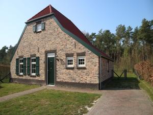 RoggelにあるNice, child friendly villa with a sauna in Limburgの緑のドアと窓のある小さなレンガ造りの建物