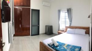 1 dormitorio con 1 cama y puerta a una habitación en Motel Thân Thiện 2, en Vung Tau