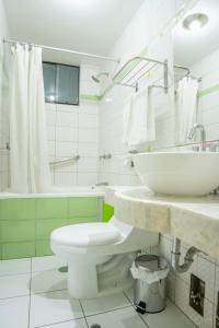 La salle de bains blanche est pourvue d'un lavabo et de toilettes. dans l'établissement Apart Hotel Incamin, à Arequipa