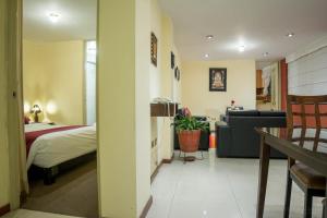 um quarto com uma cama e um sofá num quarto em Apart Hotel Incamin em Arequipa