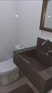 a bathroom with a toilet and a sink at Apartamento in Bombinhas