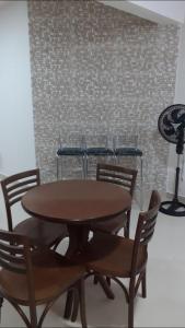 a dining room table and chairs with a brick wall at Apartamento in Bombinhas