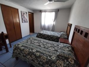 a hotel room with two beds and a window at Hotel Posadas Ocampo By Rotamundos in Salvatierra
