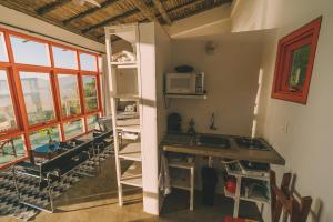 a room with a kitchen with a counter and a microwave at Pousada Pedra Grande in Praia do Rosa