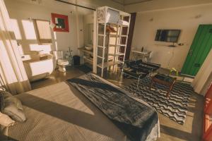 a bedroom with a bed and a living room with a television at Pousada Pedra Grande in Praia do Rosa