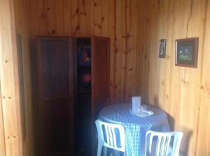 a room with a table and two chairs and a door at Pousada Cachyto de Cielo in Campos do Jordão