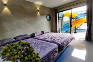 a bedroom with a purple bed and a slide at Lounge in Loft HuaHin Pool Villa บ้านพักในหัวหิน in Ban Wang Bot
