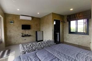 a bedroom with a large bed and a tv at Lounge in Loft HuaHin Pool Villa บ้านพักในหัวหิน in Ban Wang Bot