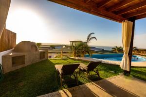 un patio trasero con mesa, sillas y piscina en Casas Lua & Mar - Vichayito - Máncora en Vichayito
