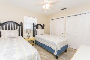 ein Schlafzimmer mit zwei Betten und einem Deckenventilator in der Unterkunft Villa Franca bungalow in Sarasota
