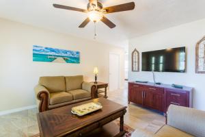ein Wohnzimmer mit einer Couch und einem Deckenventilator in der Unterkunft Villa Franca bungalow in Sarasota