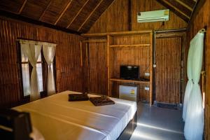 sypialnia z łóżkiem i telewizorem w obiekcie AoNang Bamboo Pool Resort w Aonang Beach
