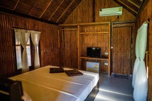 a bedroom with a bed and a tv in it at AoNang Bamboo Pool Resort in Ao Nang Beach