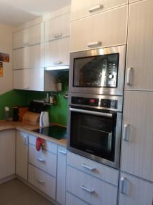 a kitchen with white cabinets and a microwave at Chata Mego Brata in Limanowa