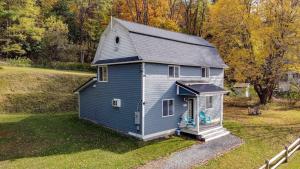 une petite maison bleue assise dans un champ dans l'établissement 1st Class Rentals Cooperstown New 3 Bedroom House, à Cooperstown