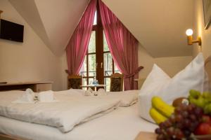 a bedroom with two beds and a window with fruit at Hotel Schwarzbeerschänke Pobershau in Pobershau